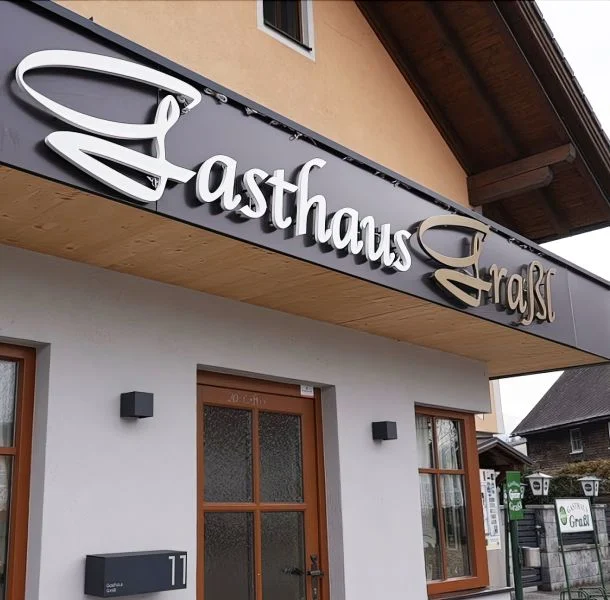 Schriftzug am Gasthaus Graßl bei Tageslicht